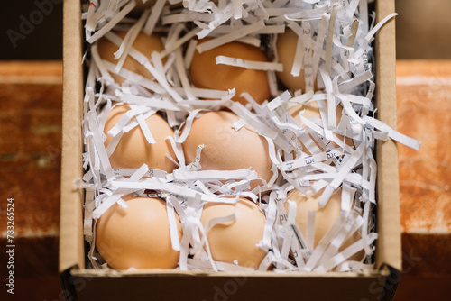Eggs nestled in shredded paper in a box photo
