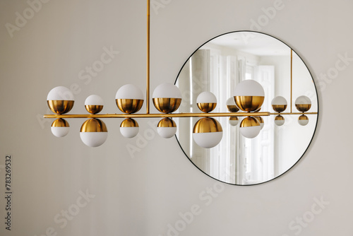 elegant ceiling lamp and circular mirror in a luxury apartment photo
