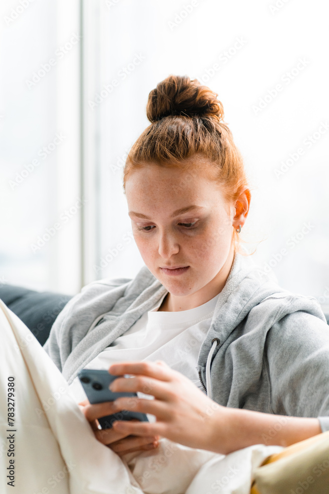 A woman uses a mobile phone at home