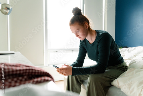 A woman uses a mobile phone at home photo