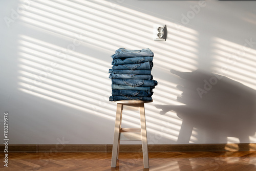 Neatly folded denim jeans on chair photo