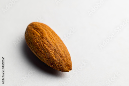 Almonds on a white background, close-up of the seed from the side. One nut macro shot
