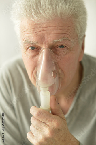 Obraz na płótnie Close-up portrait of an elder man making inhalation w salonie