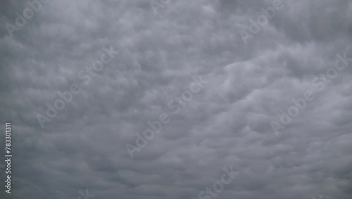 Natural structure of gray clouds moving in acceleration across sky - background, timelapse. Topics: texture, weather, meteorology, atmosphere, air, space photo