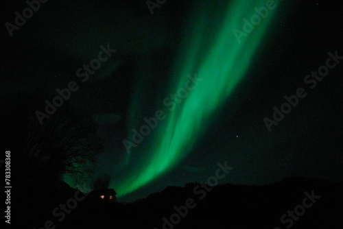 Arctic aurora over isolated cottage