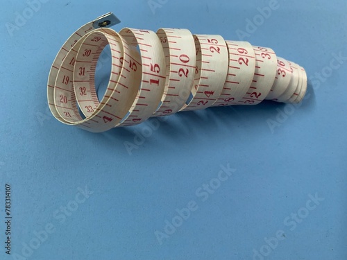 measuring tape curled on a blue background