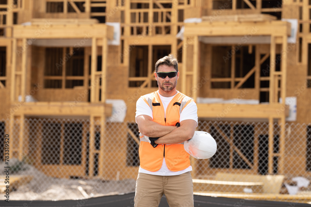 roofer builder working on roog structure of building on construction site. handsome young male builder in hard hat smiling at camera. Construction Worker on Duty. Contractor and the Wooden House Frame roofer builder working on roog structure of building on construction site. handsome young male builder in hard hat smiling at camera. Construction Worker on Duty. Contractor and the Wooden House Frame