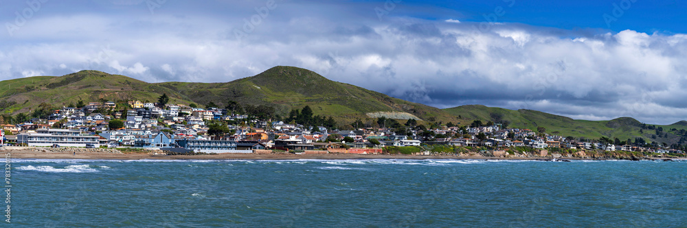 Panorama of beach, ocean city on coast with hills