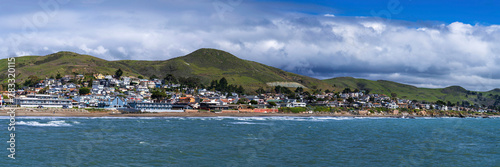 Panorama of beach, ocean city on coast with hills
