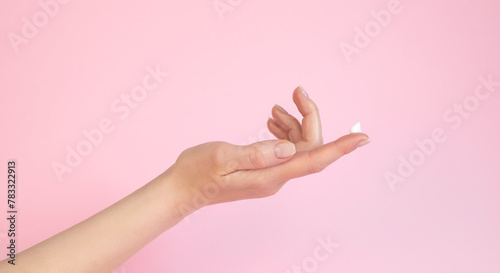 Female hand with cream on the finger. The concept of female beauty.
