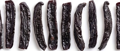   A tight shot of black beans against a pristine white backdrop, accented by clippings nearby photo