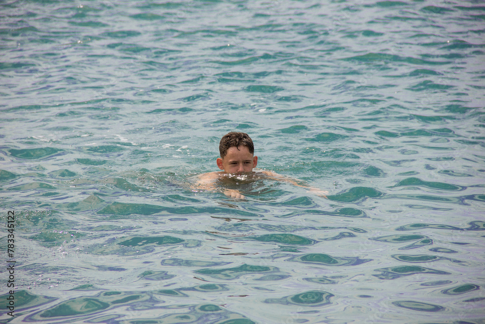 A young man is swimming.