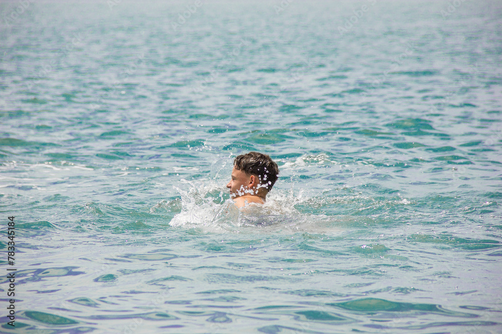 A young man is swimming.