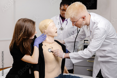 Female doctor examining male mannequin