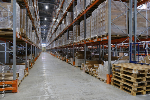 Logistics warehouse with goods on shelves of racks.