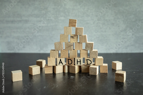 Building blocks stacked in pyramid with the words ADHD hand written on them. photo