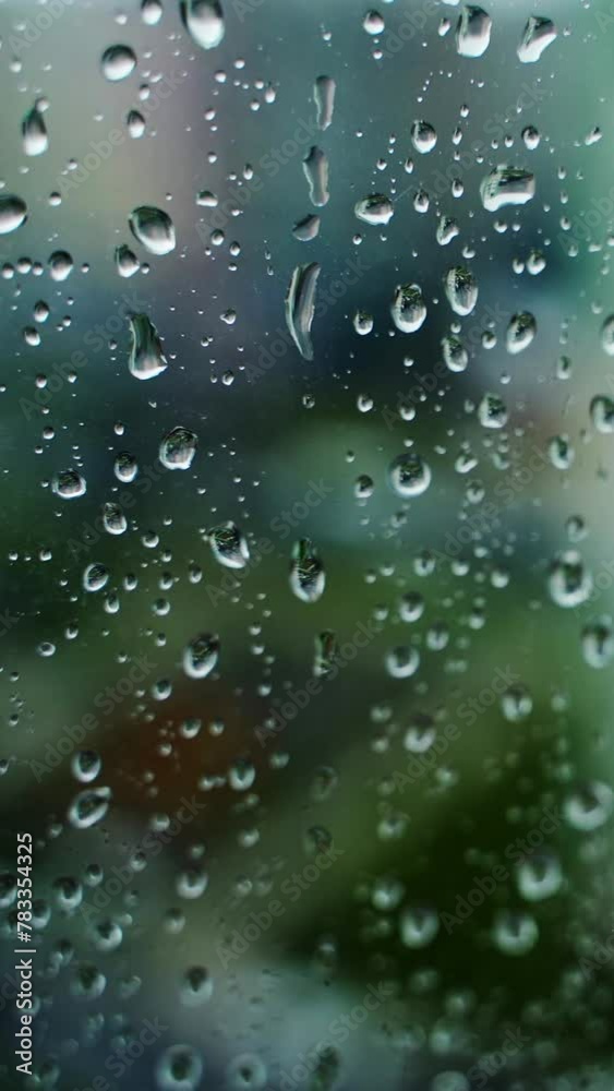 Rain drop on glass window on blur city view background. Raining weather. Water drops background. Close-up. Vertical video Rain drop on glass window on blur city view background. Raining weather. Water drops background. Close-up. Vertical video