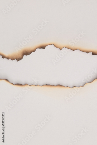 Empty old torn burned grunge pieces texture cardboard paper hole on beige white background. photo