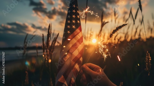 Happy 4th of July Independence Day. Hands holding sparklers celebration with American flag at sunset nature background, soft focus. Concept Independence,Memorial,Veterans