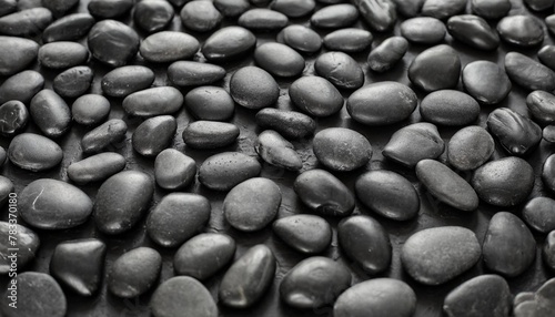 black background black pebbles of irregular shape evenly poured onto the surface monochrome photo