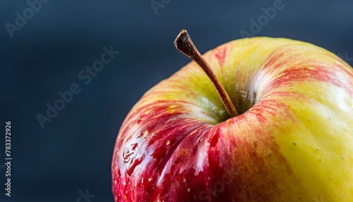 a close up of a red and yellow apple with a stem