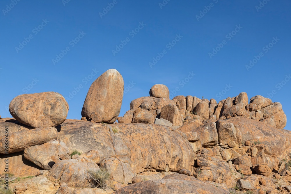 Picture of a rugged rock formation in the savannah in the south of Namibia near Fish River Canyon under a blue sky Picture of a rugged rock formation in the savannah in the south of Namibia near Fish River Canyon under a blue sky