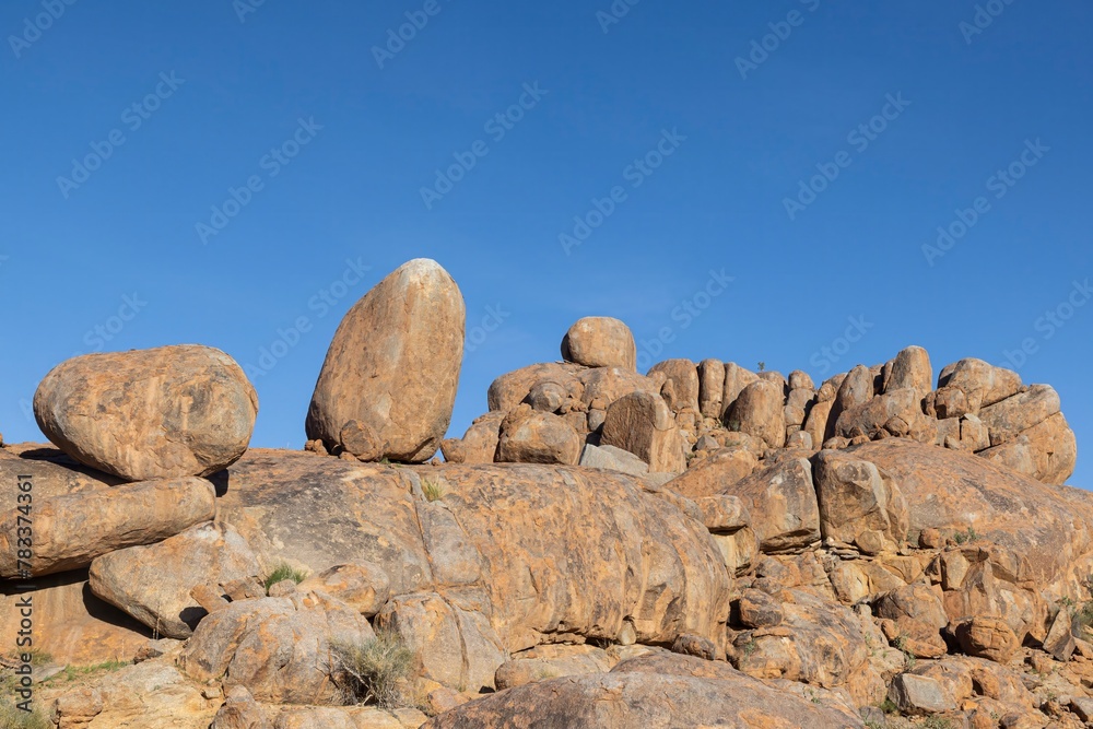 Picture of a rugged rock formation in the savannah in the south of Namibia near Fish River Canyon under a blue sky