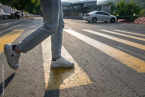 Man's legs crossing the road, yellow lines stock photo photo