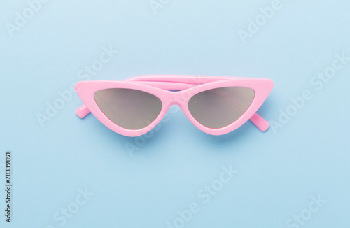 Stylish pink sunglasses on color background, top view. Summer concept