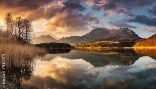 Panoramic wild sunset scenery with lake reflections and dramatic sky