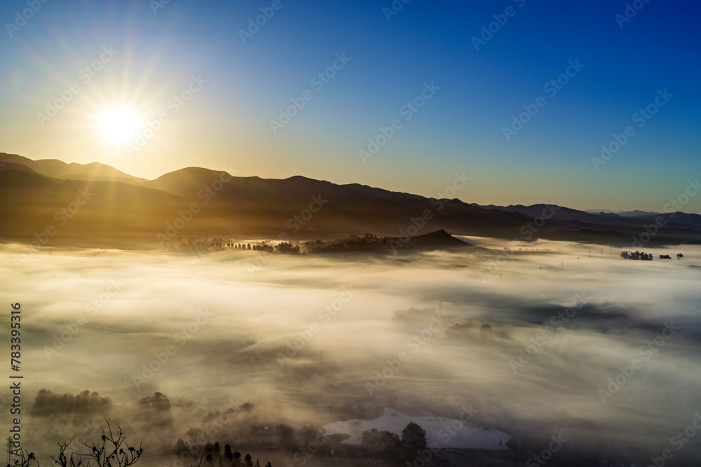 sunlight over valley, fog, clouds, from view over mountains