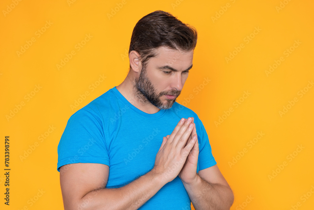 Christian Religion. A man is praying to God. Calm spiritual handsome man praying. Serious peaceful man with joining hands praying. Belief concept. Man praying. Male pray.