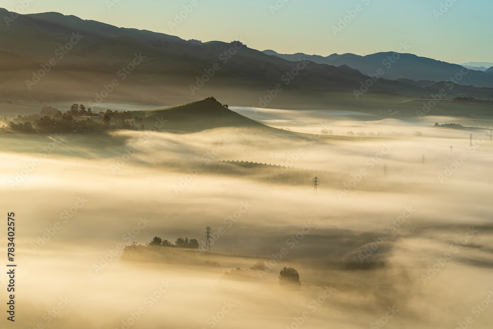 Valley full of fog, electrical towers, road from view