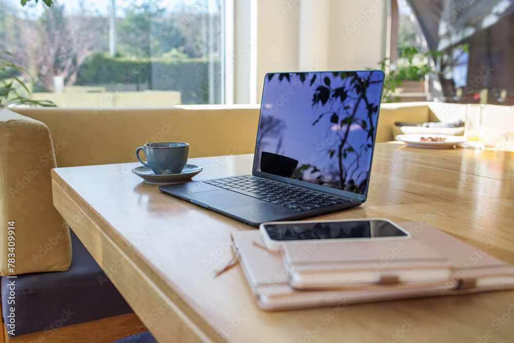Fototapeta premium Remote Work Setup with Laptop, Coffee, and Smartphone