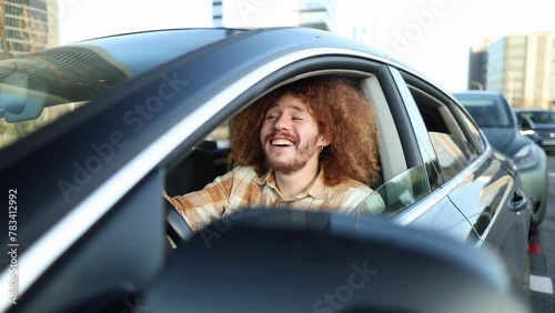 man in his car holding the steering wheel while singing happily and combing his hair and grooming his eyebrows