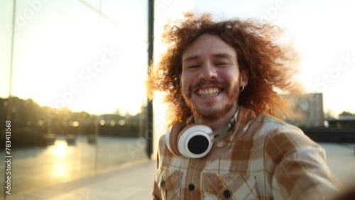 red-haired man records himself with his phone running looking at the camera - video call, live video social networks