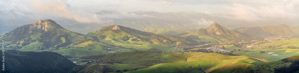 Panorama of valley, hills, mountains from view in sunlight after storm