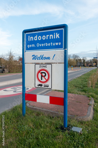Place name sign for the village of Indoornik, municipality of Overbetuwe, the Netherlands, with the text 'welcome' below (and no parking for trucks or buses in this zone) photo