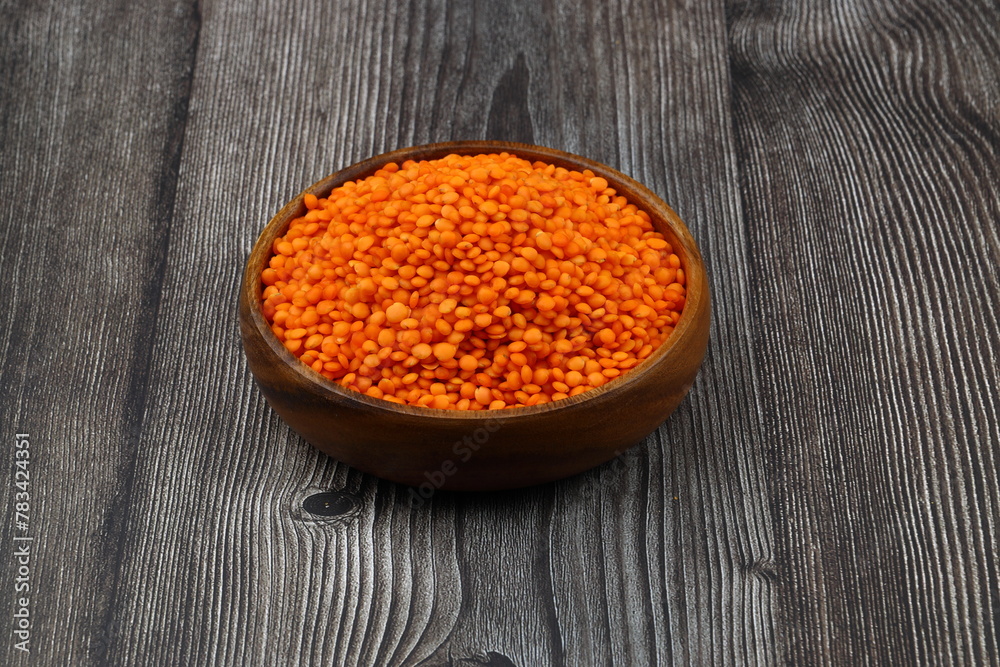 Red lentils in wooden bowl on wooden table background. Top view, copy space. Flat lay. Red lentils in wooden bowl on wooden table background. Top view, copy space. Flat lay.