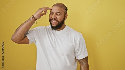 Oops! frustrated african american man standing in despair, hand on head, realizing a foolish mistake. isolated over yellow background, bad memory error concept. photo