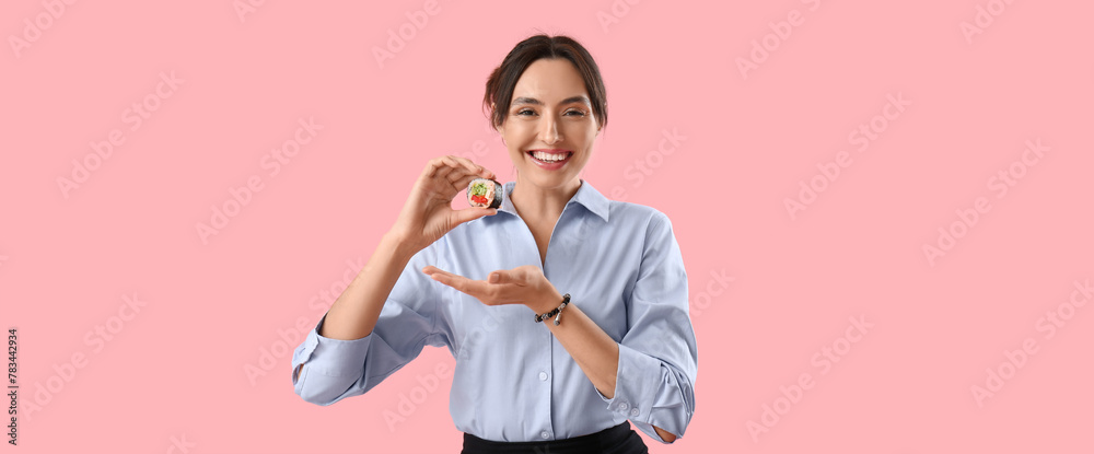 Naklejka premium Happy young woman with tasty maki roll on pink background