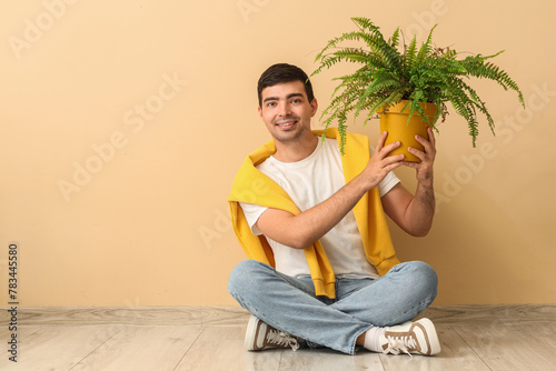 Young man with plant sittin...