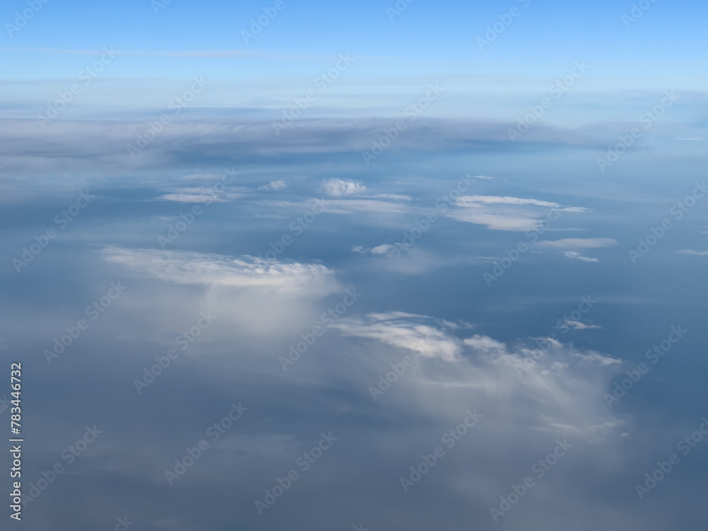 White cirrus clouds on a bright turquoise sky. Top view