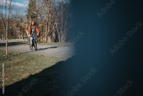 A man enjoys a leisurely bike ride through a park, basking in the sunlight and serene outdoor setting.