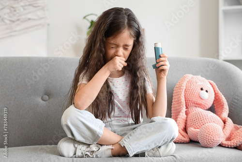 Little girl with inhaler having asthma attack at home photo