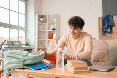 Male student packing backpa...