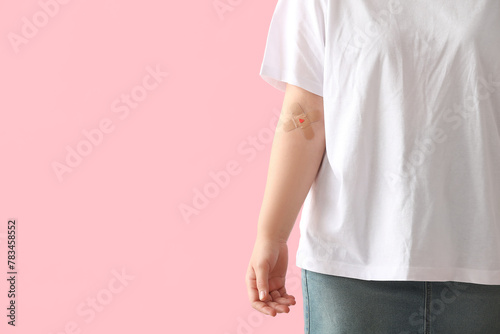 Blood donor with applied medical patches on pink background photo