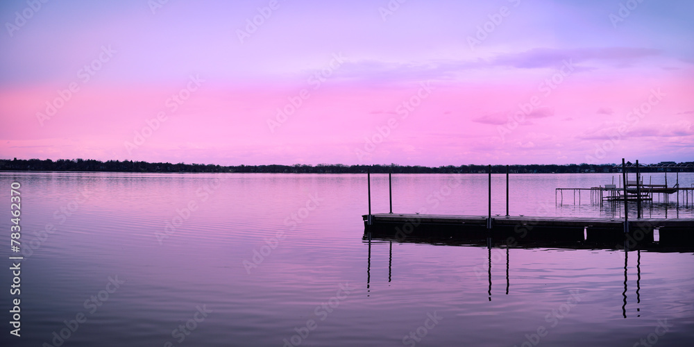 Obraz premium Tranquil relaxing sunset landscape over the dock at Schluter Beach in Monona Lake, Dane County, Wisconsin, United States, a suburb of the state capital Madison