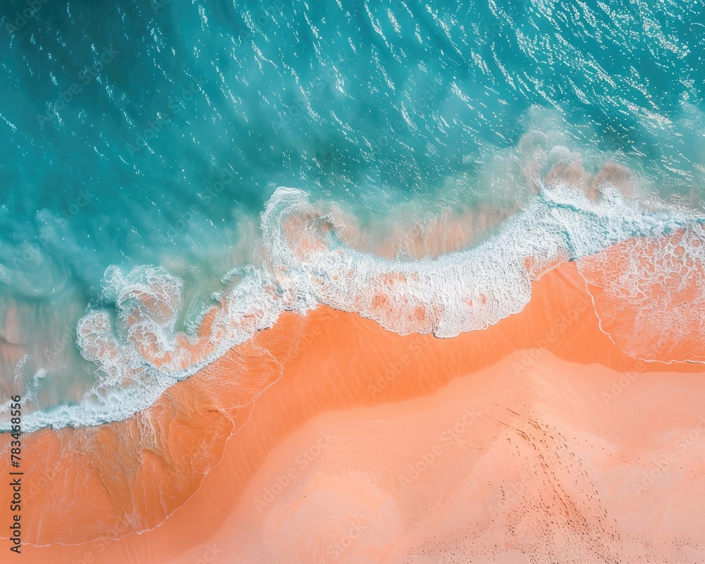 Fototapeta premium Aerial view of a beach where the orange sand meets the azure sea
