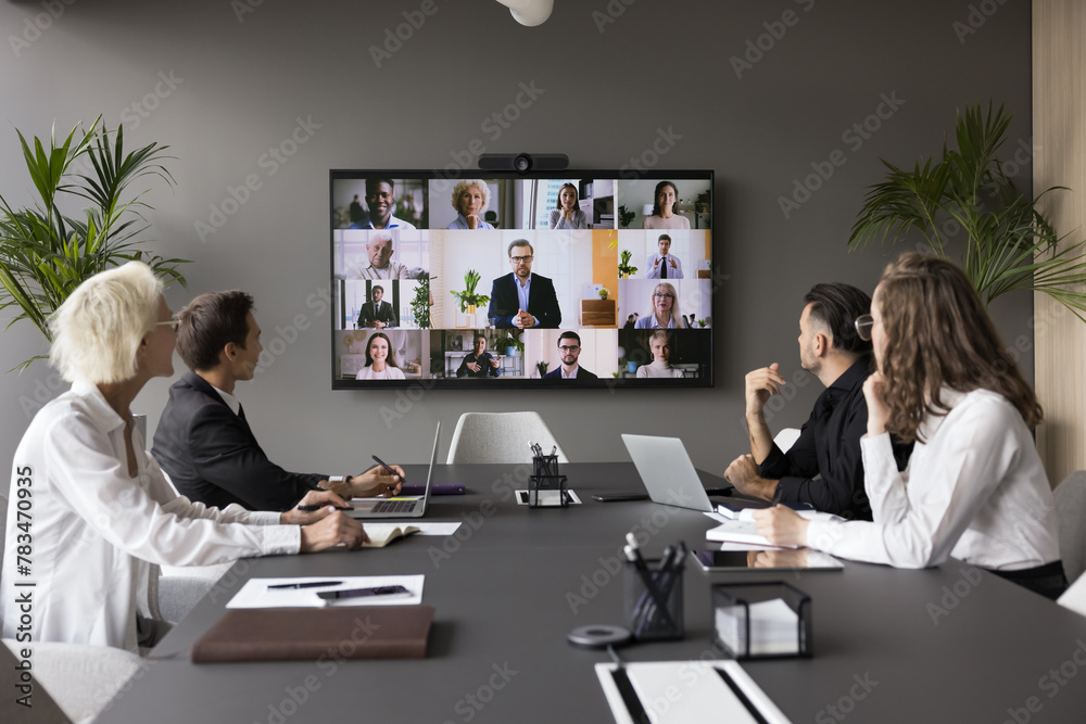 Fototapeta premium Group meeting using video call app. Multiethnic businesspeople profiles on screen, engaged in teleconference event by business, international communication of HR managers and applicants, career, tech